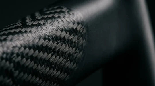 Nahaufnahme eines Carbon-Fahrradrahmens mit detaillierter Struktur nach Sturz