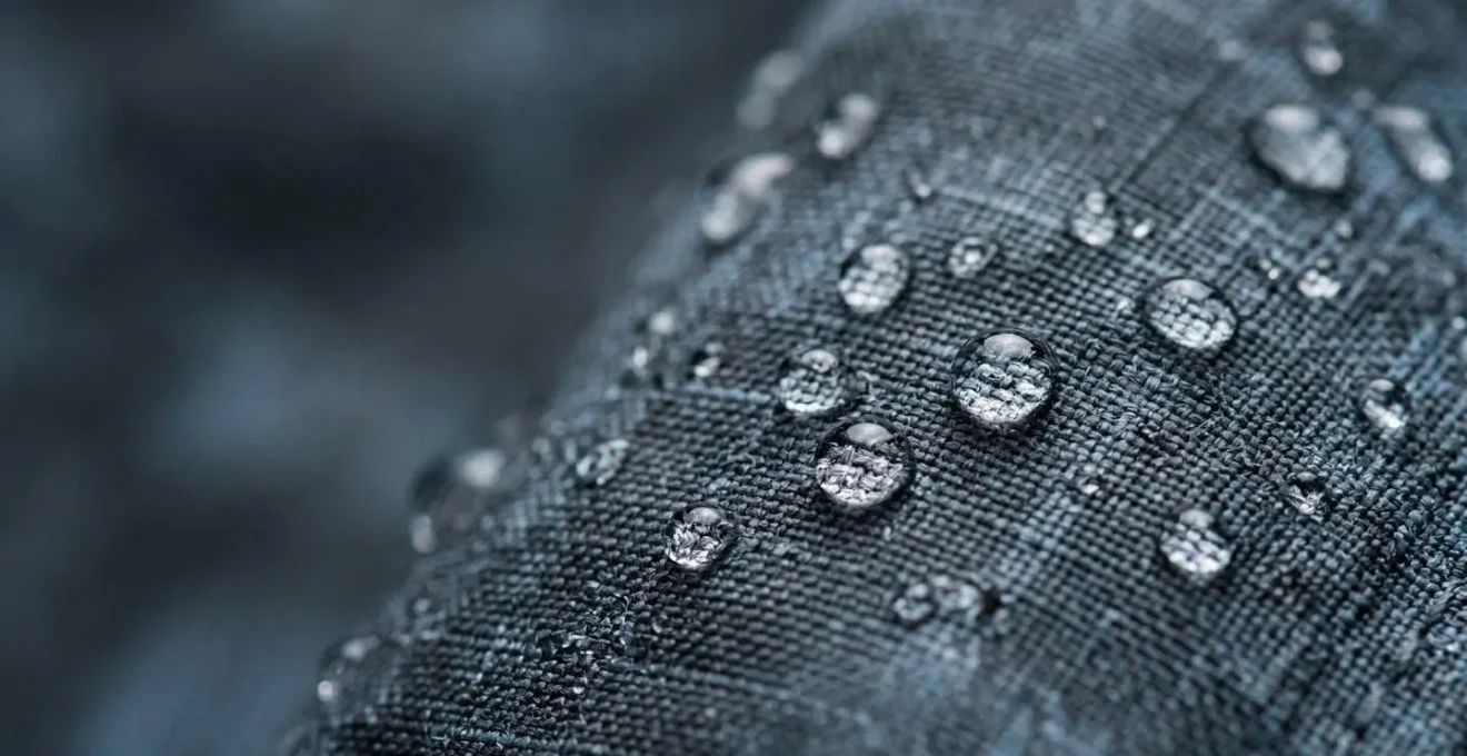 Nahaufnahme von Wassertropfen auf imprägnierter Funktionsjacke mit Abperleffekt