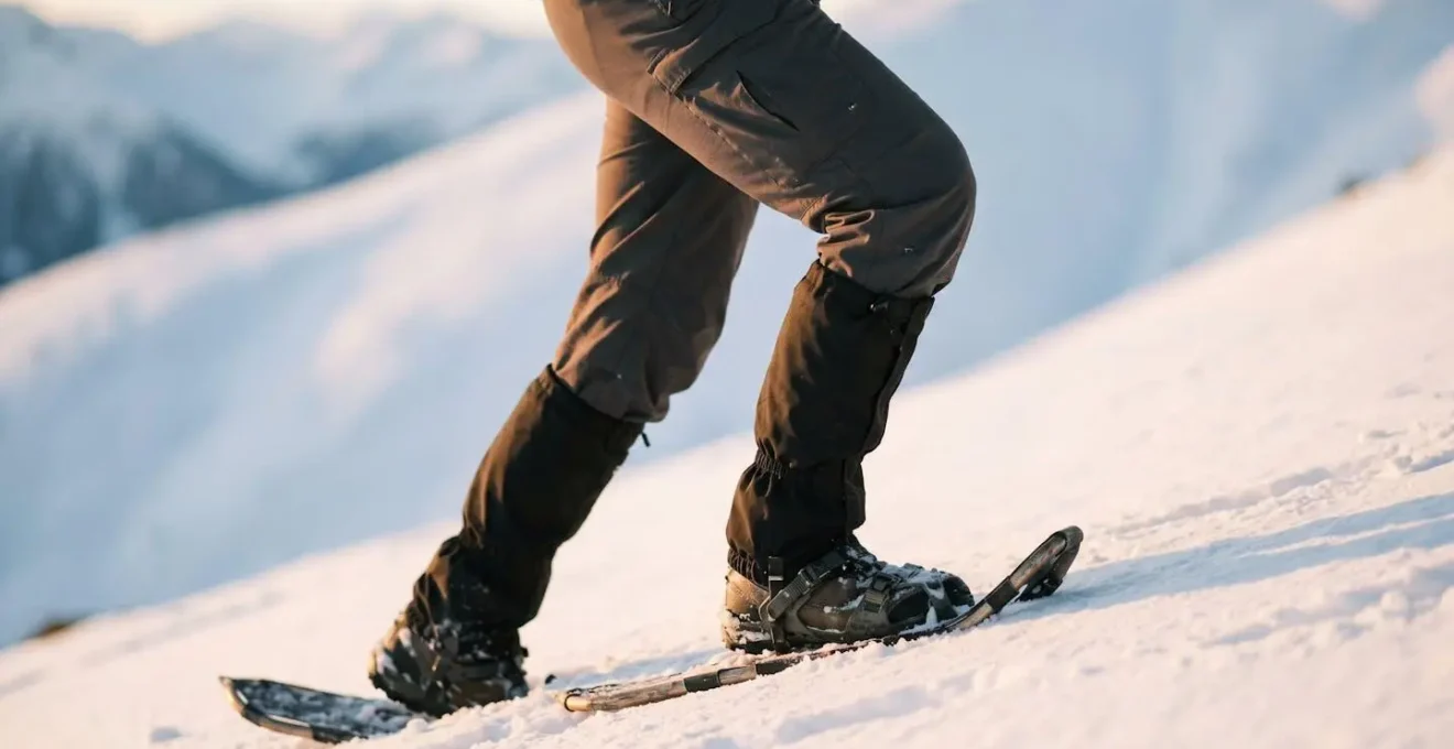 Nahaufnahme der Beinmuskulatur eines Schneeschuhwanderers bei aktivem Aufstieg im Schnee