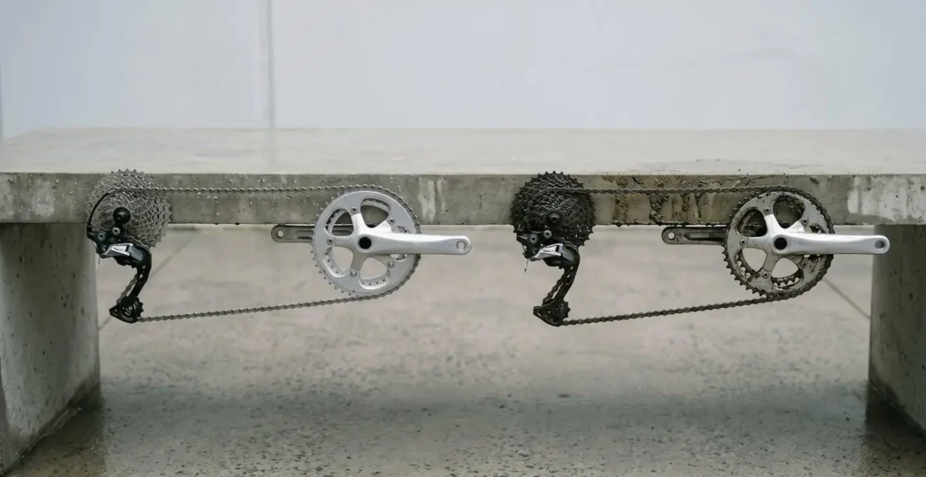 Vergleichsdarstellung von gewachster und geölter Fahrradkette nach Regenfahrt mit unterschiedlichen Schmutzanhaftungen